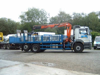 Crane-mounted flatbed lorry at the yard